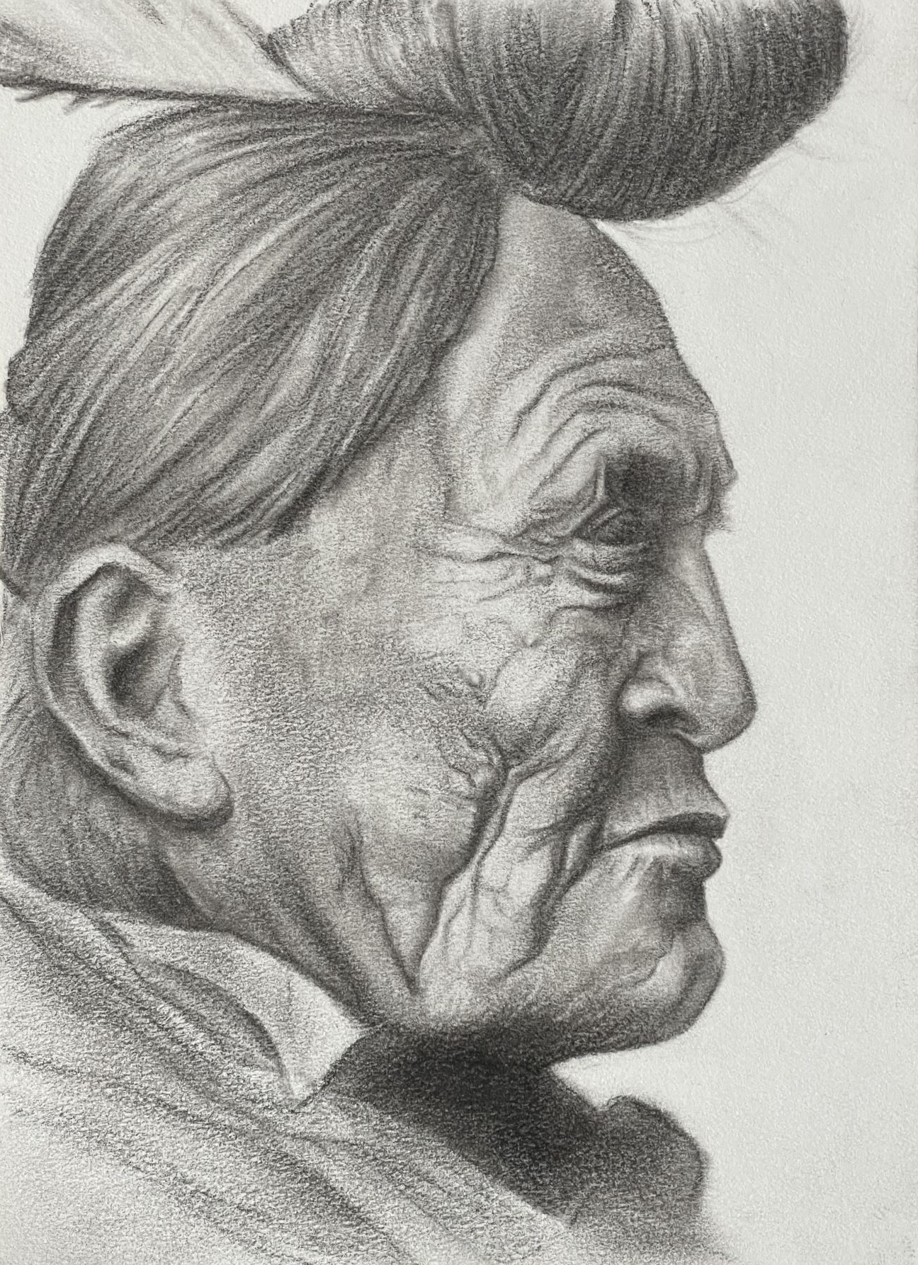 Very old Native American man with a deeply lined face, shown in profile with his hair queued on top of his head.