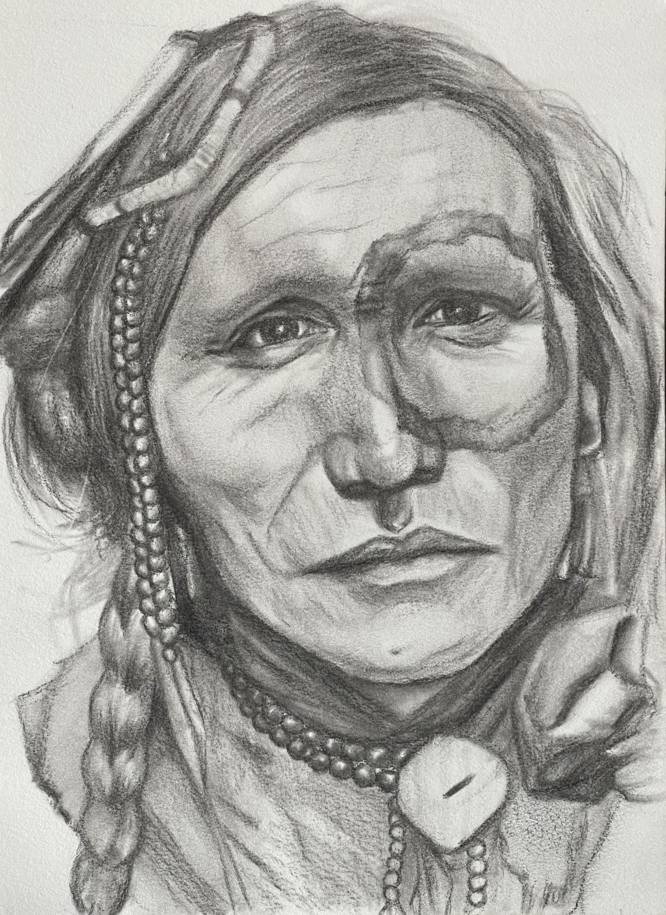 Frontal portrait of an older Native American man with traditional beads in his hair and around his neck. There is a large circle drawn around his left eye.