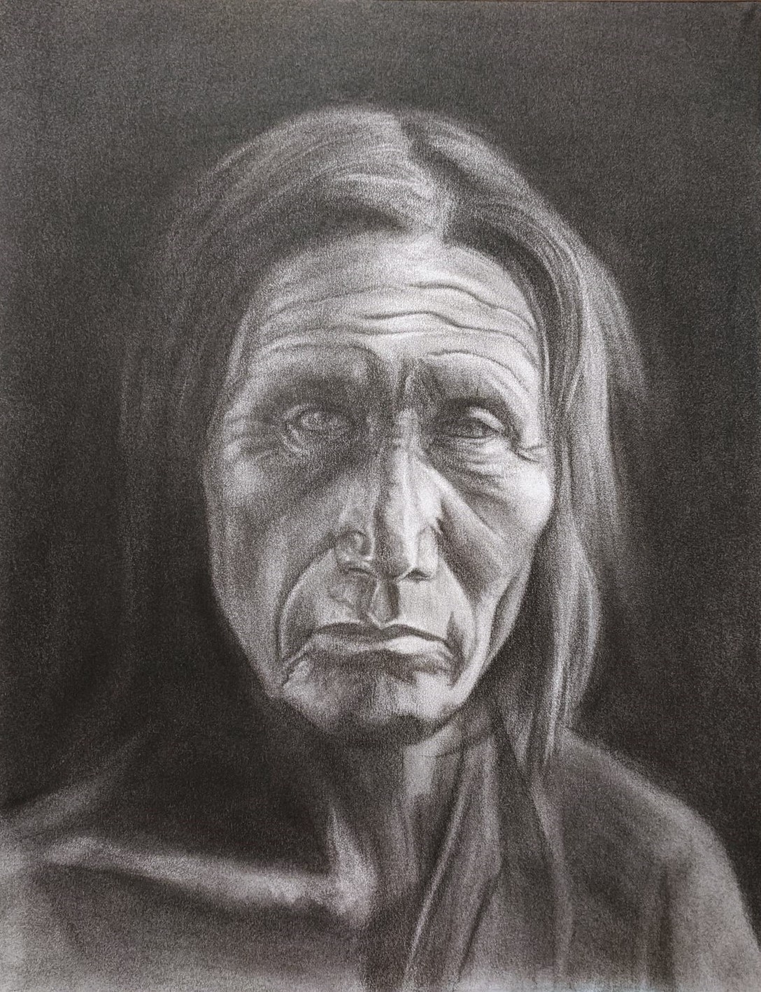 Portrait of an aged Native American man looking directly at the viewer.