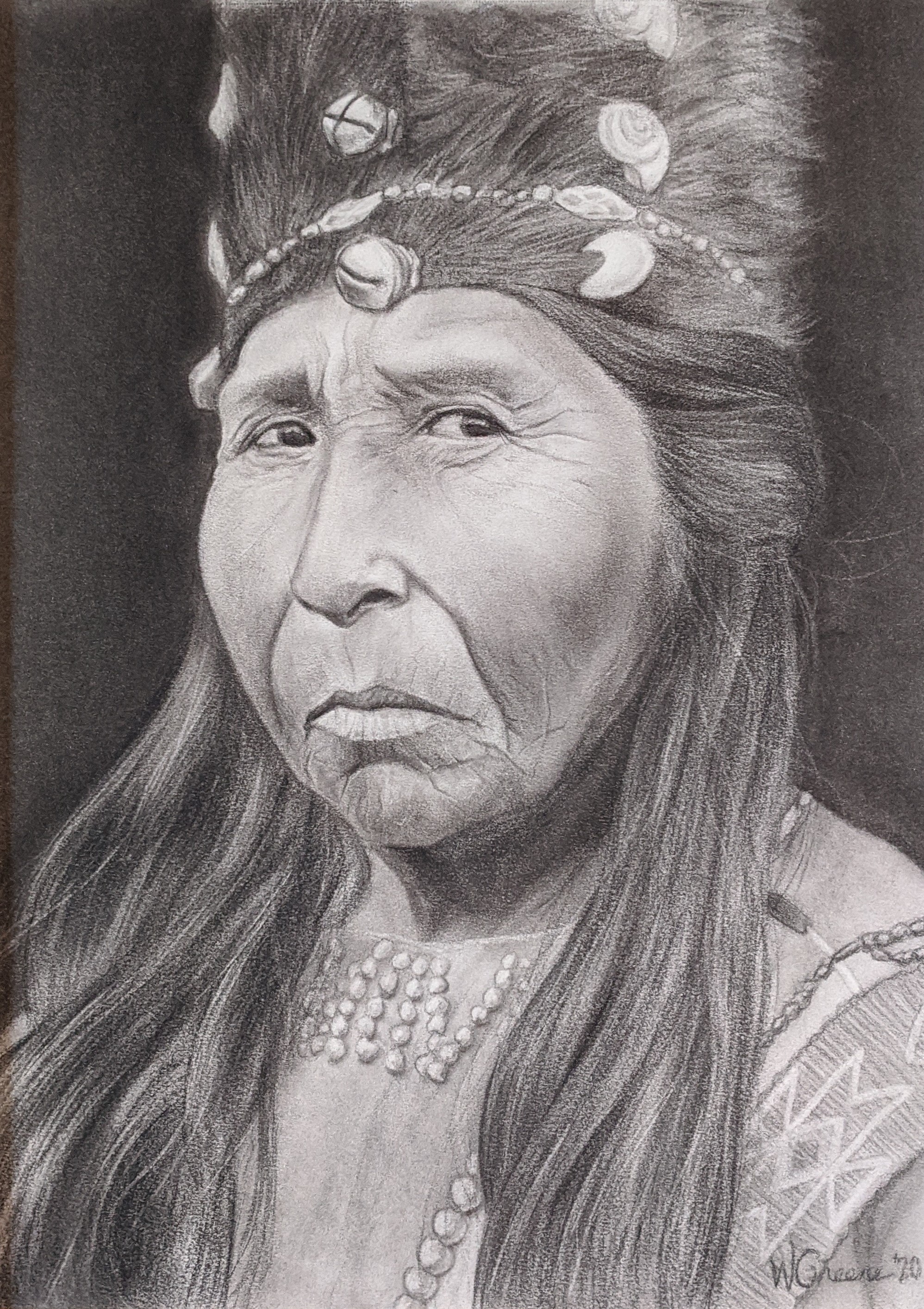 Portrait of an aged Native American woman looking directly at the viewer. She has long hair and is wearing a beaded shirt and a fur hat with shells embedded into it.