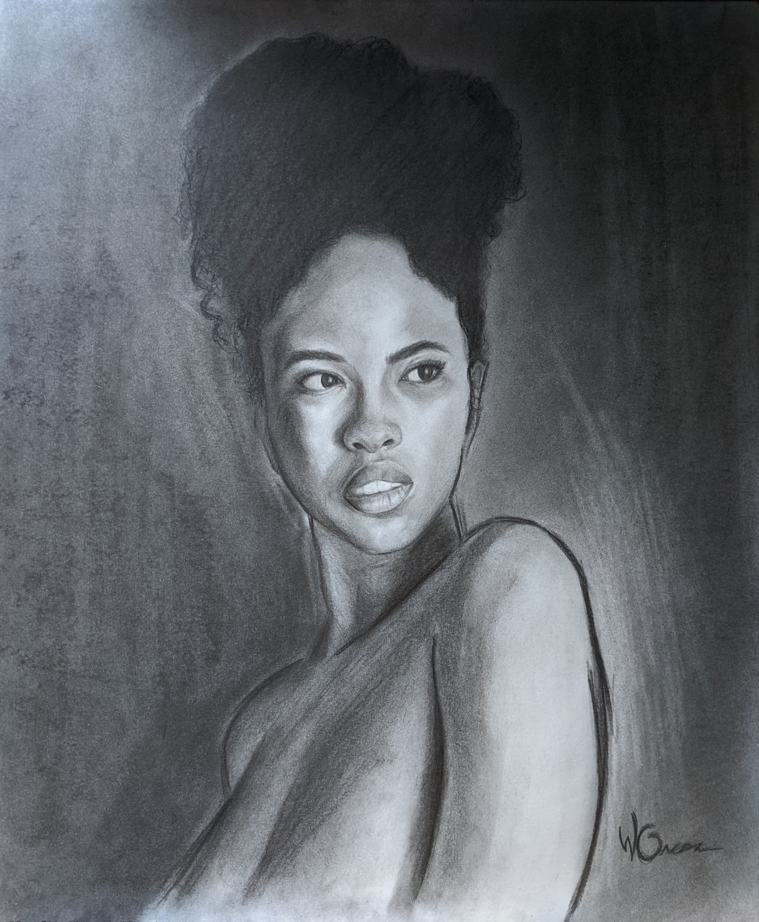 Young Black woman from the chest-up and with her hair piled on top of her head.