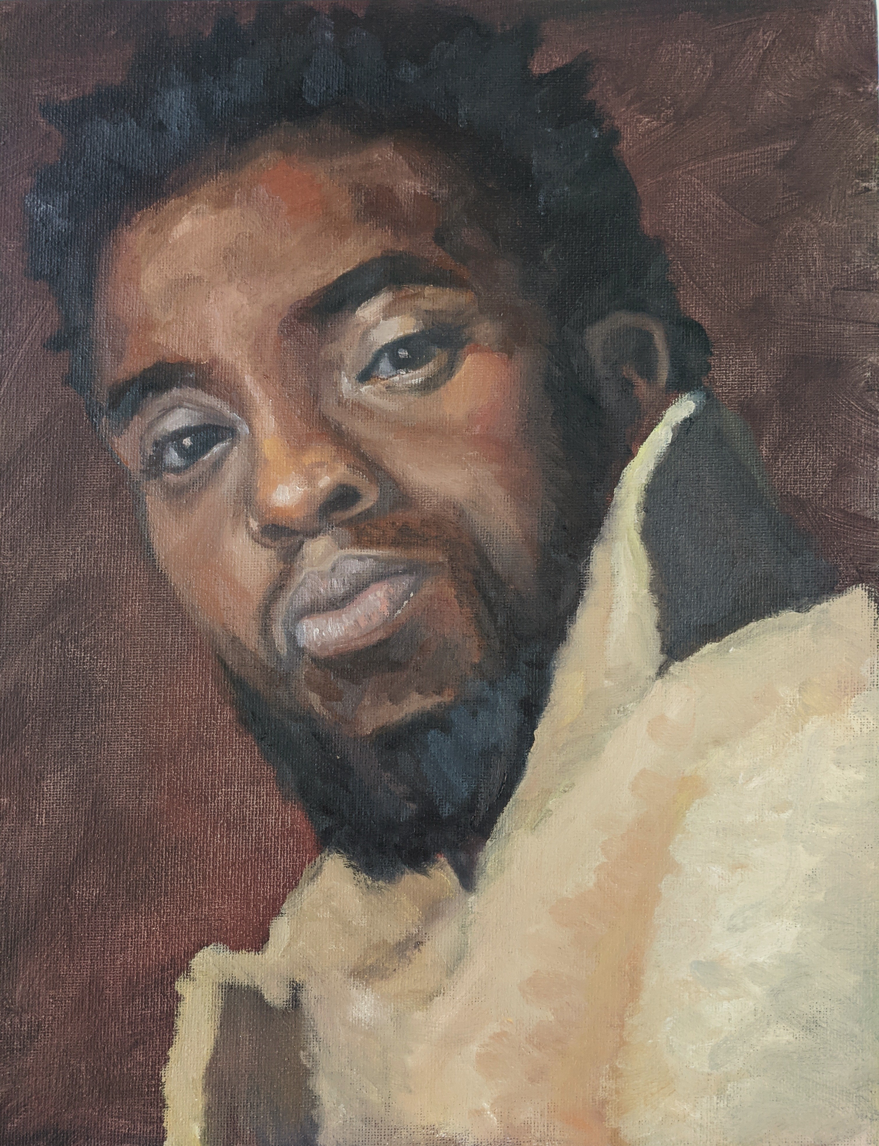 Color portrait of Chadwick Boseman, head tilted, wearing a fluffy yellow coat.