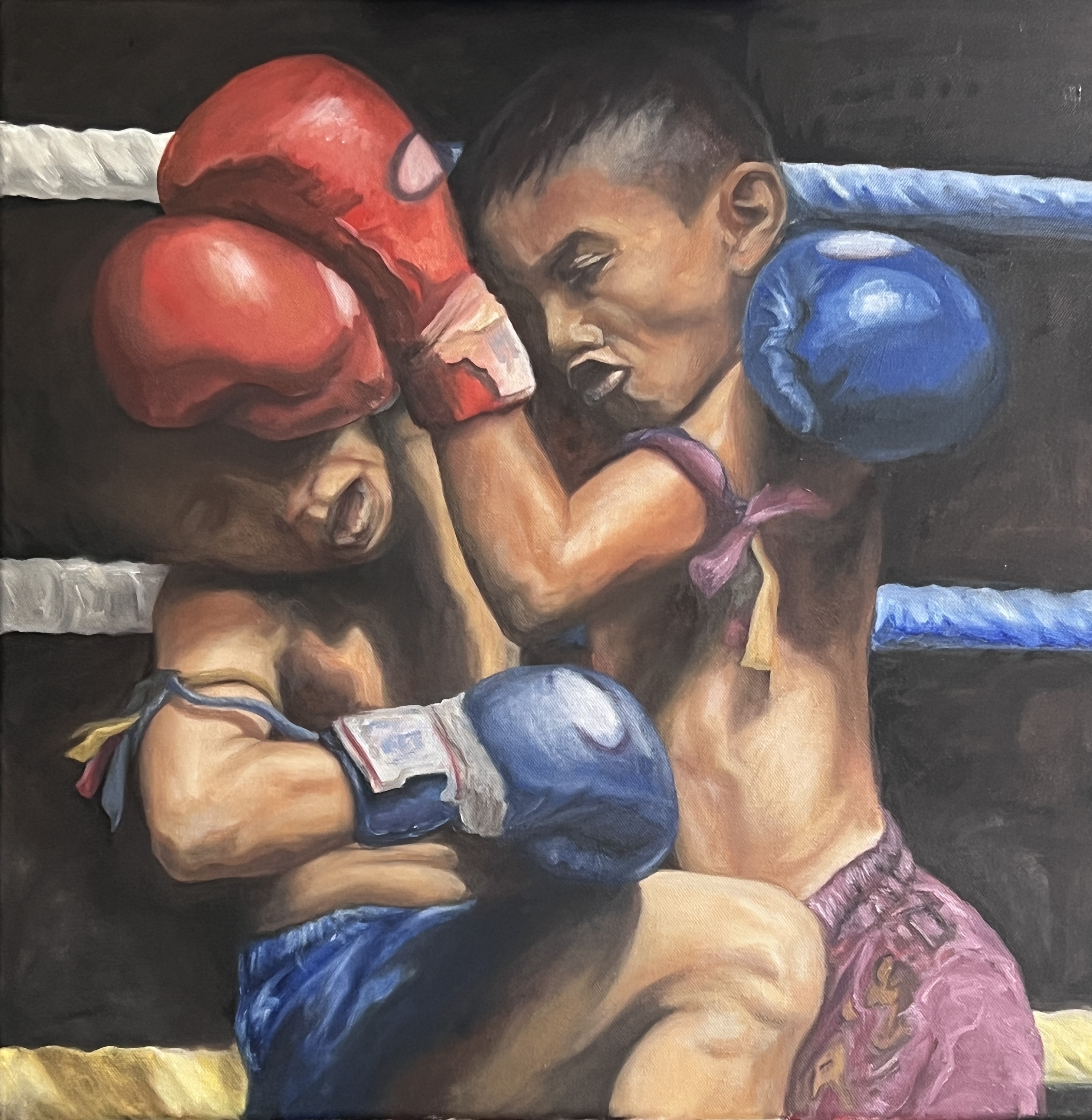Two kids about ten years old fighting Muay Thai in a stadium ring. The boys are in a clinch with one of them pressing down on the other.