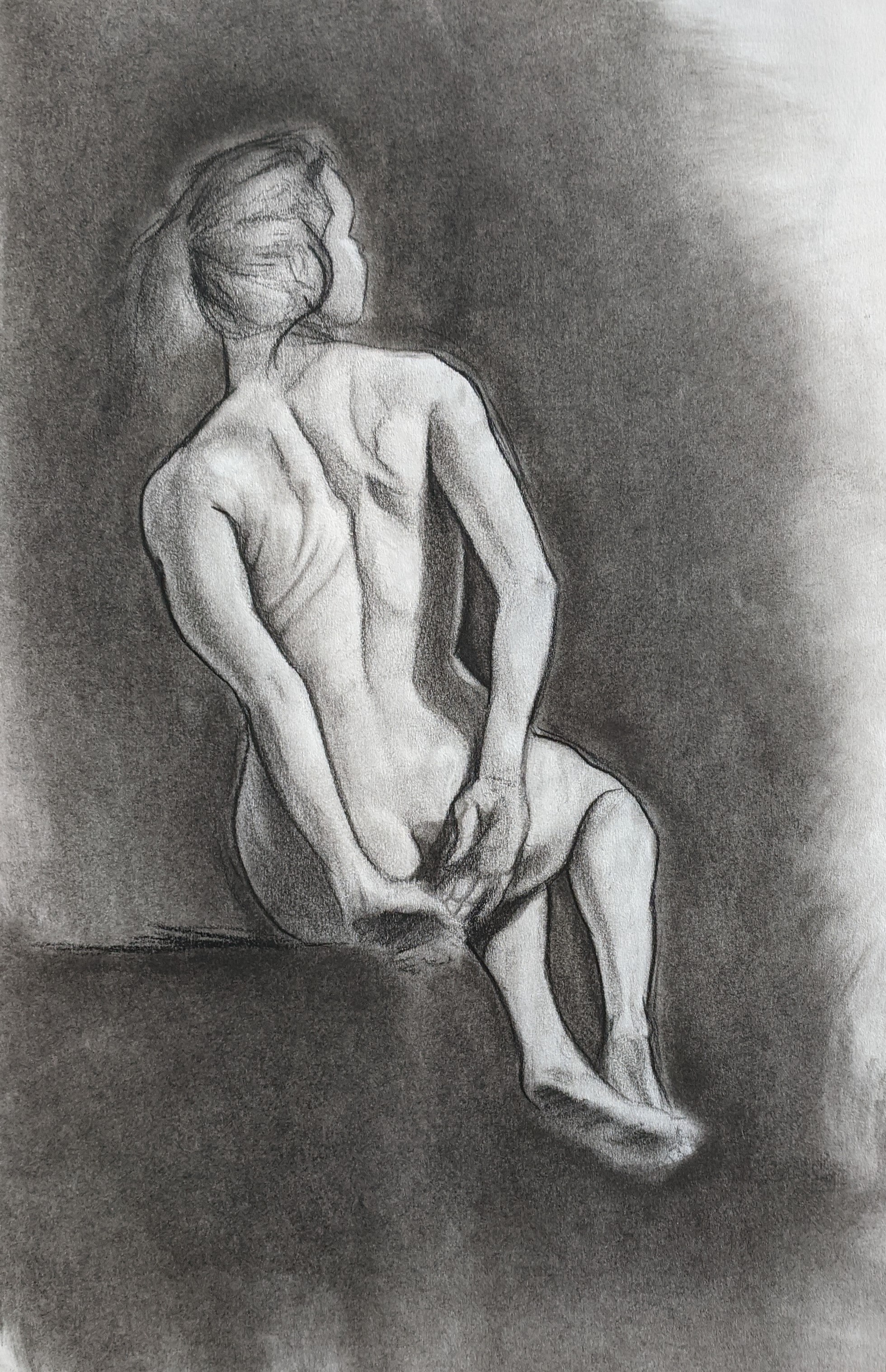 Charcoal figure study of a seated nude leaning back with her head tilted upward